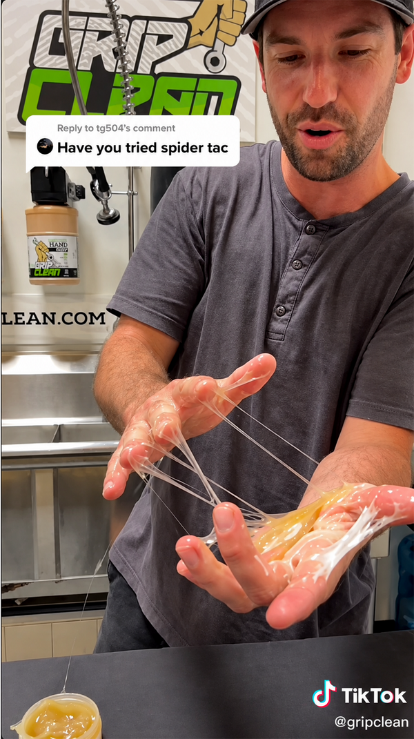 Sticky strands of Spider Tack stretching between a man's hands before he cleans them off with Grip Clean